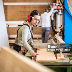 male and female carpenter at work, man and woman are crafting with wood in a workshop, two craftsmen or handymen working with carpenter tools or electric machines